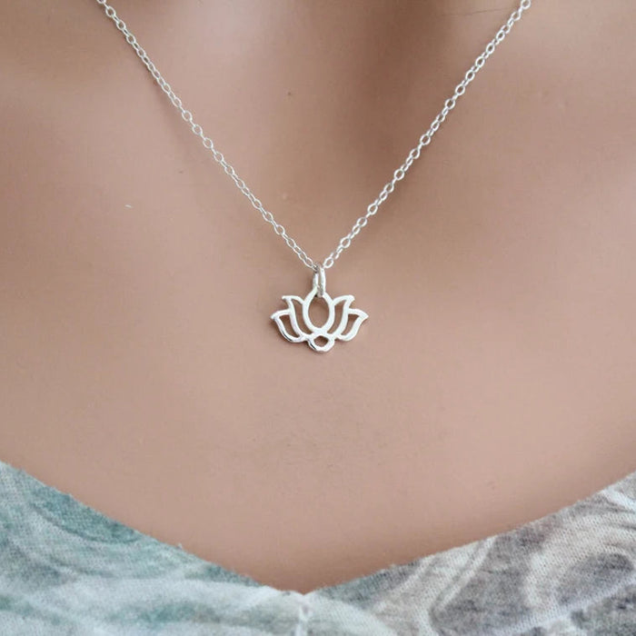Silver lotus flower necklace on a mannequin with a marble background