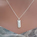 Silver necklace with 'LOVE' pendant on a neutral background