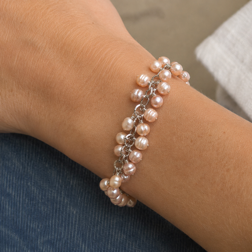 Pearl bracelet on a wrist with a neutral background