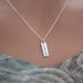 Silver necklace with 'LOVE' pendant on a mannequin