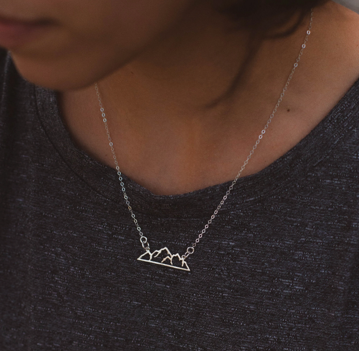 Mountain landscape outline Bar necklace in sterling silver on a young lady in gray shirt