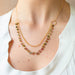 Necklace with gemstones worn by a person in a white top