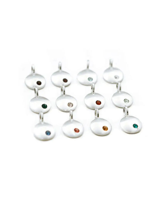 Minimalist birthstone necklace displayed flat on a white surface with focus on crystal detail.