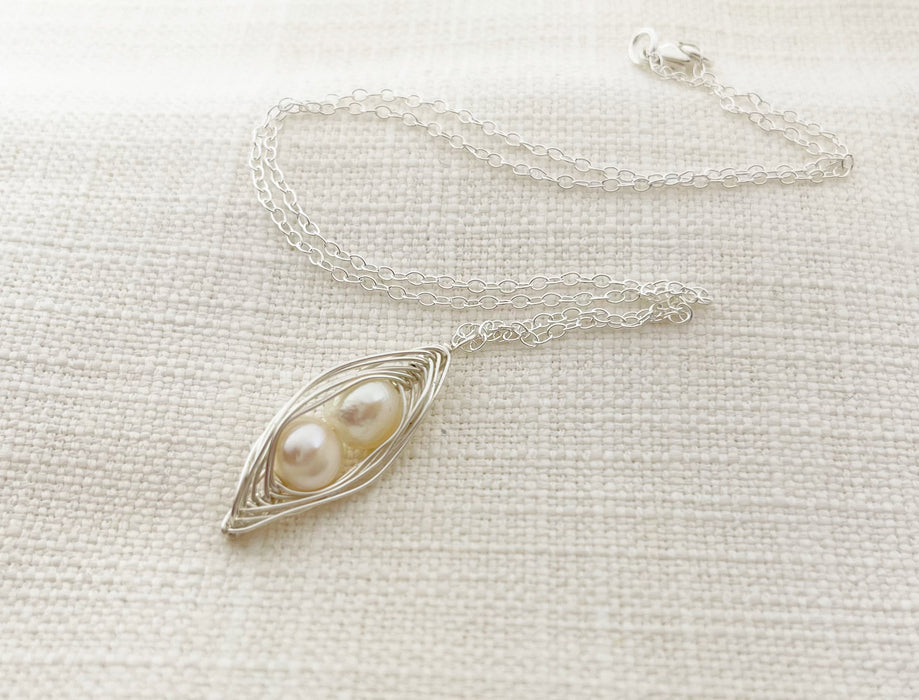 duo wire wrapped peapod in sterling silver against a neutral fabric background