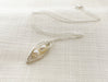 duo wire wrapped peapod in sterling silver against a neutral fabric background