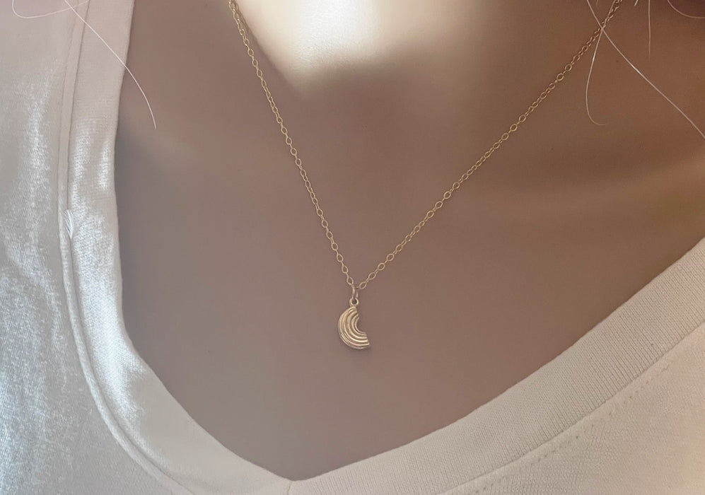 gold macaroni noodle necklace on neck of model