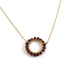 gold necklace with wire wrapped garnets in a circle shape