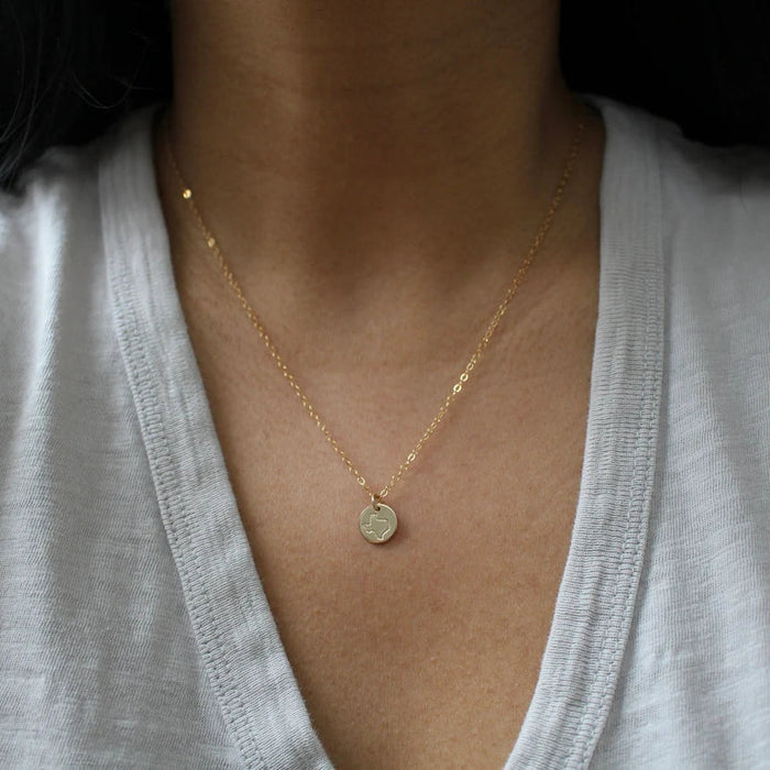 close up of woman wearing gold texas necklace