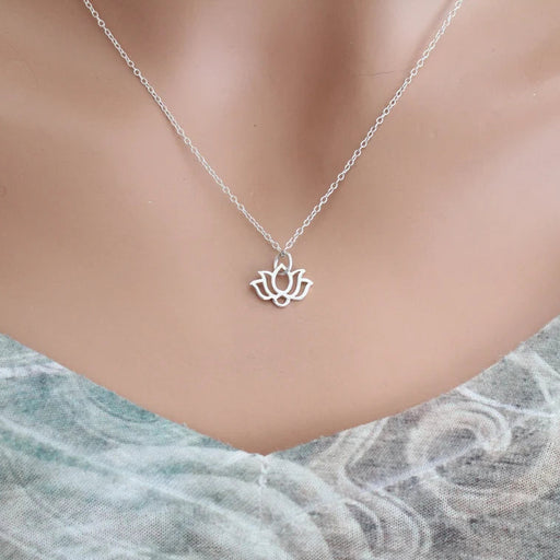 Silver lotus flower necklace on a mannequin with a light background