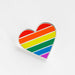 Heart-shaped pin with rainbow stripes on a white background