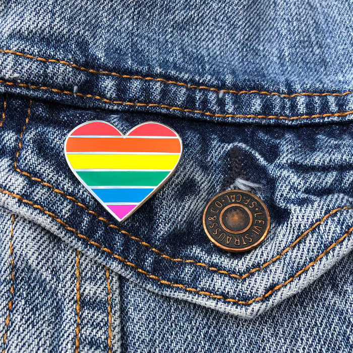 Rainbow heart pin on a denim jacket