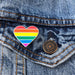Rainbow heart pin on a denim jacket