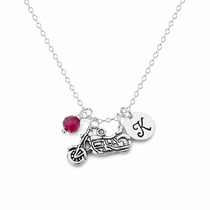 Necklace with motorcycle charm, red gemstone, and letter 'K' pendant on a white background