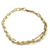 a close up of a handmade wire wrapped peridot gemstone and gold chain layered bracelet on a white background