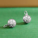 close up of 2 silver pickleball charms that are 3d, one is tilted on side