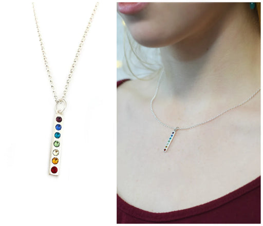 split view of a close up of a silver vertical bar pendant with a row of rainbow crystals and a view of it on a models neck on a chain