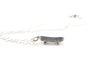 close up view of a sterling silver skateboard charm necklace on a solid white background