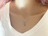 view of a lady's neck wearing a sterling silver skateboard charm necklace