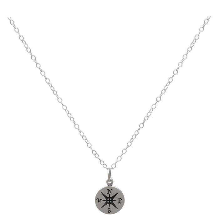 sterling silver compass charm hanging from a silver chain against a white background