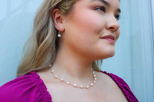 wire wrapped freshwater pearl necklace and simple handmade pearl drop earrings on a model profile view